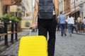 Luggage travel tourism concept, closeup of yellow suitcase in hand of walking woman Royalty Free Stock Photo