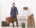 Luggage and vacation concept. Man, traveller with beard and mustache with luggage, luxury white interior background
