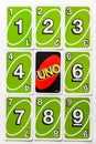 Green Uno card game cards arranged symetrically with on reversed card.