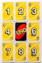 Yellow Uno card game cards arranged symetrically with on reversed card.