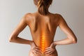 Lumbar intervertebral spine hernia, woman with back pain on a gray background, spinal disc disease, painful area highlighted in