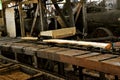 Lumber moves through a  steam powered sawmill on rollers Royalty Free Stock Photo