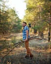 Lumberjack with an ax and firewood goes through woods. Royalty Free Stock Photo