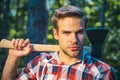 Lumberjack with ax in his hands. Handsome young man with axe near forest. Firewood as a renewable energy source. Man Royalty Free Stock Photo