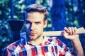 Lumberjack with ax in his hands. Handsome young man with axe near forest. Firewood as a renewable energy source. Man Royalty Free Stock Photo