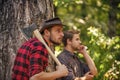 Lumberjack with chainsaw and ax. Harvest firewood. hiking in deep wood. forest care at vacation. summer or spring Royalty Free Stock Photo