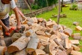 Logger is cutting firewood in the yard with chainsaw