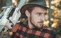 Lumberjack - close up portrait. Lumberjack with chainsaw in his hands. Woodcutter with axe or chainsaw in the summer