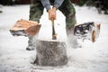 Lumberjack cutting wood in snow
