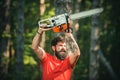 Lumberjack in the woods with chainsaw axe. Handsome young man with axe near forest. Chainsaw. Deforestation. Lumberjack Royalty Free Stock Photo