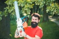 Lumberjack in the woods with chainsaw axe. Handsome young man with axe near forest. Royalty Free Stock Photo