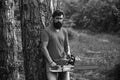 Lumberjack worker with chainsaw in the forest. Handsome young man with axe near forest. Stylish young man posing like Royalty Free Stock Photo