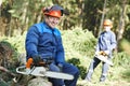 Lumberjack worker with chainsaw in the forest Royalty Free Stock Photo