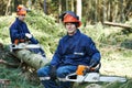 Lumberjack worker with chainsaw in the forest Royalty Free Stock Photo