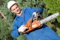 Lumberjack Worker with Chainsaw in Work Wear on Forest background