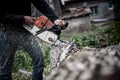 Lumberjack worker in full protective gear cutting firewood Royalty Free Stock Photo