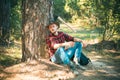 The Lumberjack working in a forest. Handsome Woodworkers lumberjack plaid shirt holding the axe on green nature Royalty Free Stock Photo