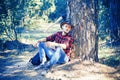 The Lumberjack working in a forest. Handsome Woodworkers lumberjack plaid shirt holding the axe on green nature Royalty Free Stock Photo