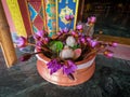 Colorful bouquet of flowers in a clay vase in the entrance of the buddhist temple.