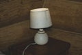 Luminous desk lamp with lampshade on dark glass surface with reflection