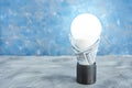 Luminous led lamp in an electric socket in a 100 dollar bill. electrical energy conservation concept Royalty Free Stock Photo