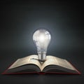 Luminous light bulb on open book. Idea or creativity concept. Ed Royalty Free Stock Photo