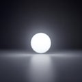 Luminous White Sphere on a Reflective Surface with Light Rays ball glowing Royalty Free Stock Photo