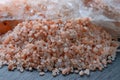 Lump of pink Himalayan salt and a bunch of large crystals of crushed edible Himalayan salt