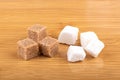 Lump white sugar and brown cane sugar cubes on a wooden background. Royalty Free Stock Photo