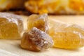 Lumpy cane caramel sugar is located on a wooden substrate Royalty Free Stock Photo