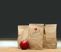 Lunch bags with apple on school desk Royalty Free Stock Photo