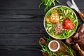 Lunch bowl with buckwheat porridge, fried chicken cutlets and fresh vegetable salad of arugula, lettuce, chard leaves, tomato Royalty Free Stock Photo