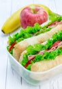 Lunch box with ciabatta bread sandwiches, apple, banana Royalty Free Stock Photo