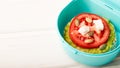 Lunch box with a rice cake sandwich and avocado with tomato and feta cheese with pumpkin seeds with copy space Royalty Free Stock Photo