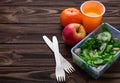 Lunch box with salad, apple, tangerine and juice. Royalty Free Stock Photo