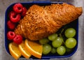 Lunch box with a sandwich croissant and fruit healthy snacks for school