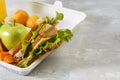 Lunch box with a sandwich, fresh vegetables and fruits, a bottle of juice on a light background. Healthy school lunch. Eco Royalty Free Stock Photo