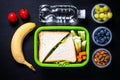 Lunch box with sandwich, vegetables, banana, water, nuts and ber