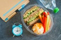 Lunch box with sandwich, vegetables, water and fruits on black chalkboard. Royalty Free Stock Photo