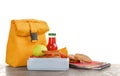 Lunch box with tasty food and bag on table against white background Royalty Free Stock Photo