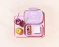 Lunch box with yogurt, cereal bar, apple and oatmeal berries cocktail on a pink background Royalty Free Stock Photo