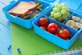 Lunch boxes with appetizing food and notebook on color wooden table Royalty Free Stock Photo