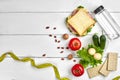 Lunch boxes with sandwich and fresh vegetables, bottle of water, nuts and eggs on white wooden background. Top view with Royalty Free Stock Photo