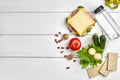 Lunch boxes with sandwich and fresh vegetables, bottle of water, nuts and eggs on white wooden background. Top view with Royalty Free Stock Photo