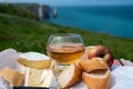 Lunch on green grass fields on chalk cliffs of Etretat, french cheese camembert and apple cider drink with Atlantic ocean on