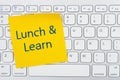 Lunch and Learn message on yellow sticky note on a gray keyboard