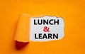 Lunch and learn symbol. Words `Lunch and learn` appearing behind torn orange paper. Beautiful orange background. Business,