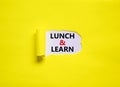 Lunch and learn symbol. Words `Lunch and learn` appearing behind torn yellow paper. Beautiful yellow background. Business,