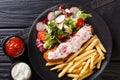 Lunch menu fried pollock with french fries and fresh salad close-up on a plate and sauce. horizontal top view