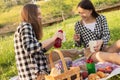 Lunch in the open air in the Park. Two young girls on a picnic eating, drinking lemonade, having fun, laughing, talking Royalty Free Stock Photo